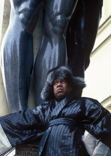 Andre Leon Talley, Vogue magazine's editor at large on his visit to Russia. ALT stands next to one of two giant Atlases guarding the side entrance to Hermitage Museum, St. Petersburg. Andre Leon Talley's outfit consists of kimono by Christian Dior Haute Couture and fur hat by Prada.