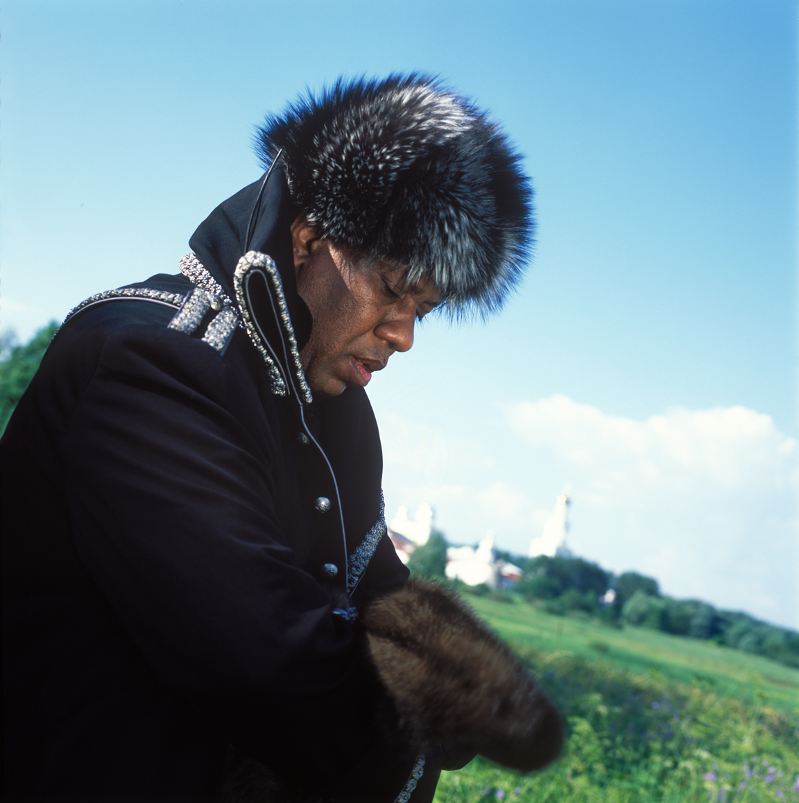 Andre Leon Talley, Vogue magazine's editor at large on his visit to Russia. This picture was taken in Vitoslavitsa Open-Air Museum near Novgorod the Great. Andre Leon Talley's outfit consists military style coat by Christian Dior Haute Couture, silver fox fur hat by Prada, mink mittens by Chado Ralp Rucci.