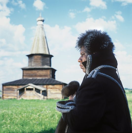 Andre Leon Talley, Vogue magazine's editor at large on his visit to Russia. This picture was taken in Vitoslavitsa Open-Air Museum near Novgorod the Great. Andre Leon Talley's outfit consists military style coat by Christian Dior Haute Couture, silver fox fur hat by Prada, mink mittens by Chado Ralp Rucci.