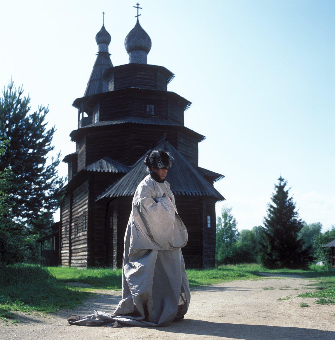 Andre Leon Talley, Vogue magazine's editor at large on his visit to Russia. This picture was taken in Vitoslavitsa Open-Air Museum near Novgorod the Great. Andre Leon Talley's outfit consists of a gown by Oscar de la Renta and silver fox fur hat by Prada.